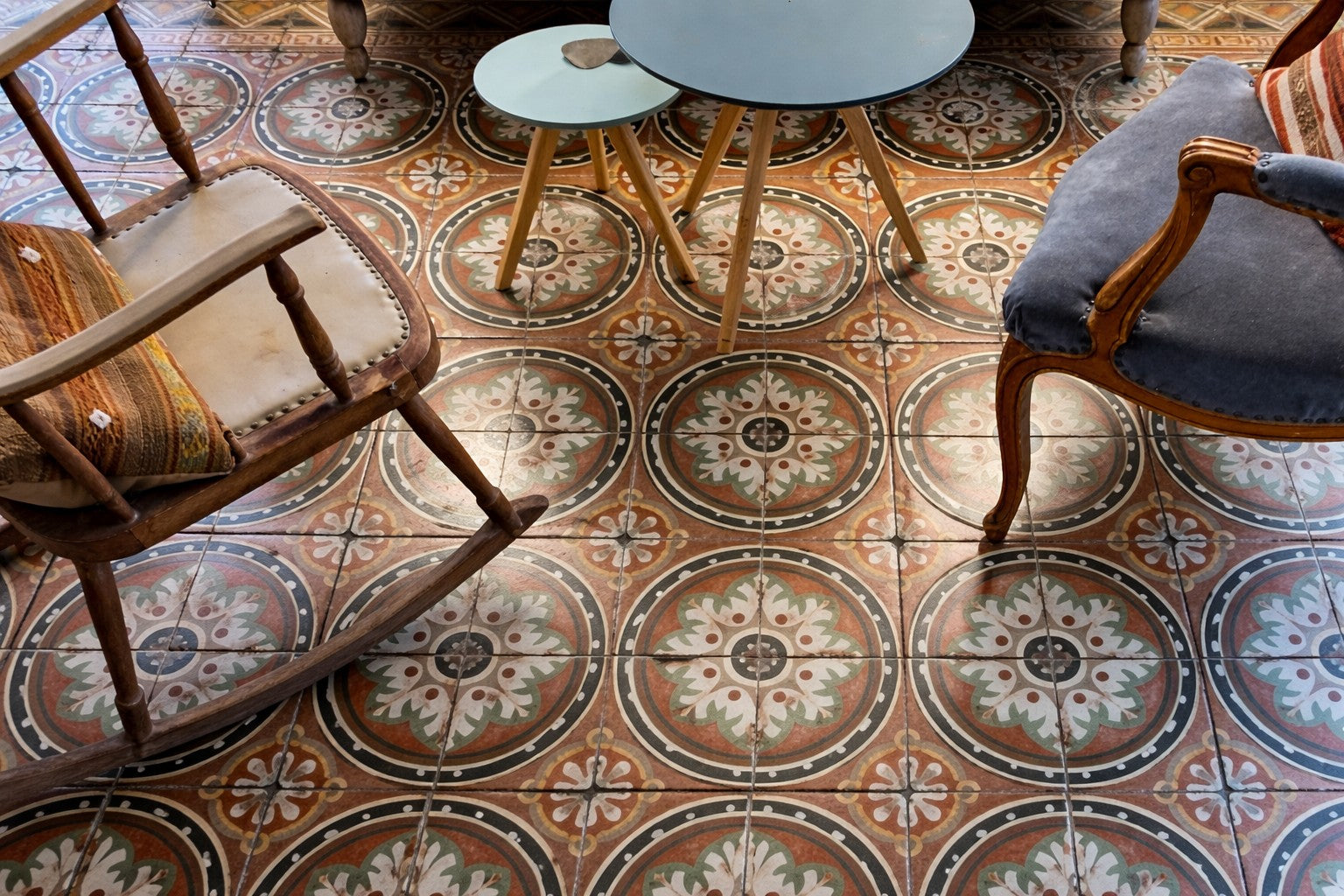 Decorative tiled floor with patterned tiles and wooden chairs.