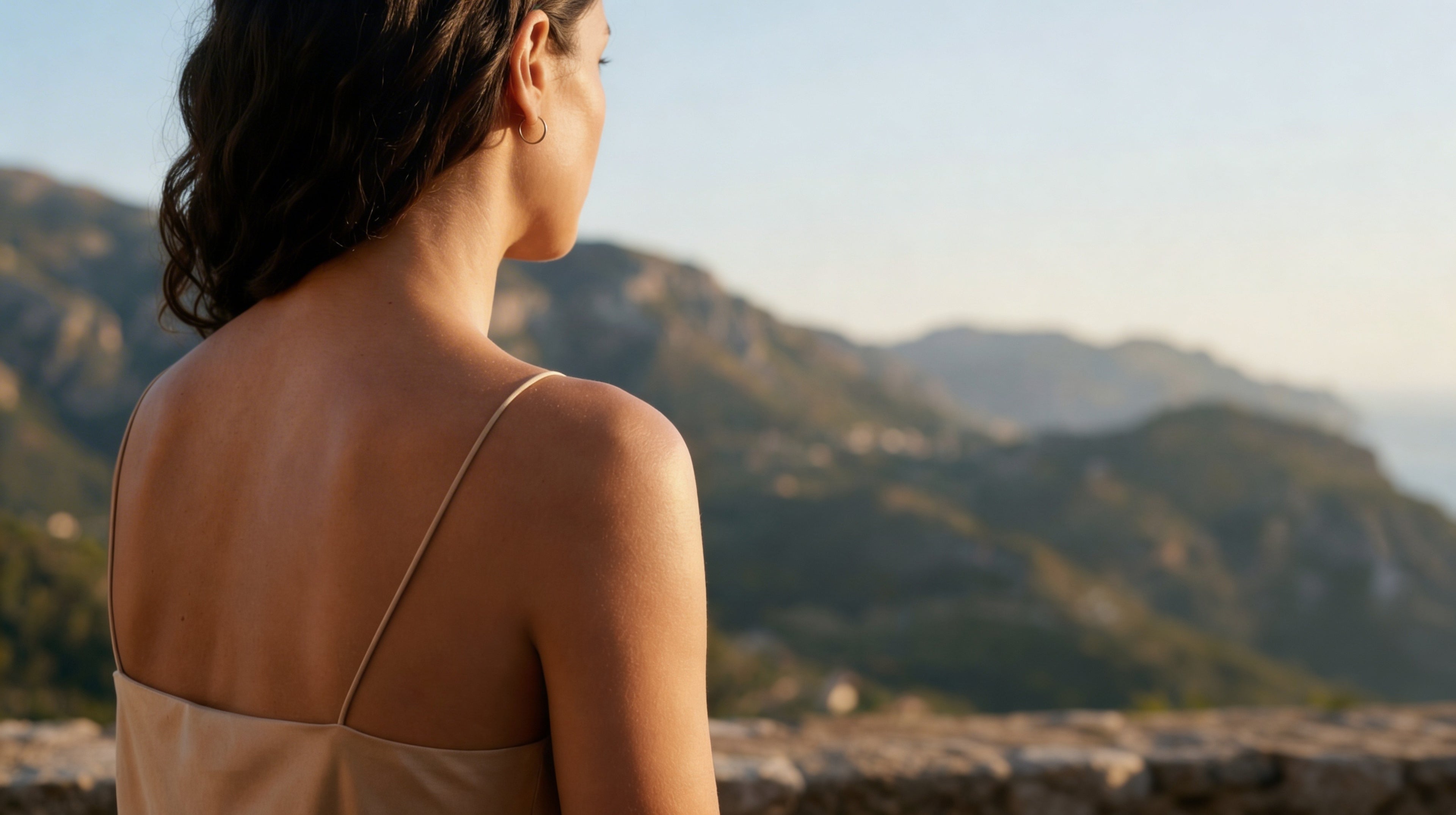 Large format of hero image portraying a content woman, enjoying the mar i muntanya view, representing the Mateixa sensorial body care concept.